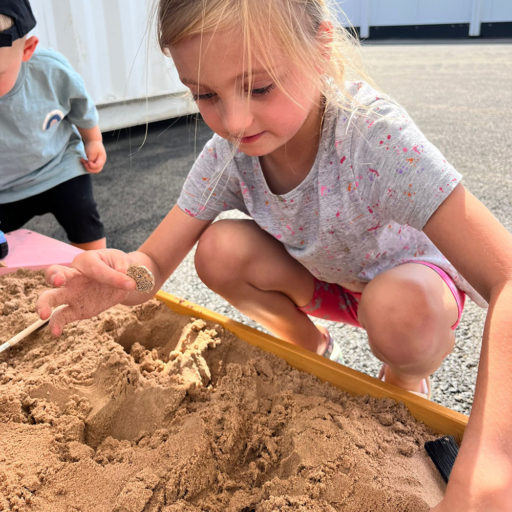 photo of child in sand pit